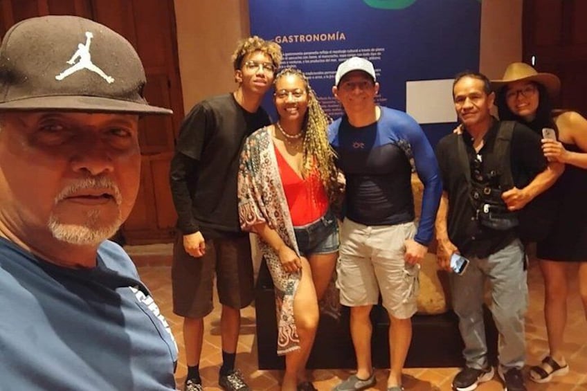 A group of people posing for a photo in an indoor setting with a banner in the background. 5
