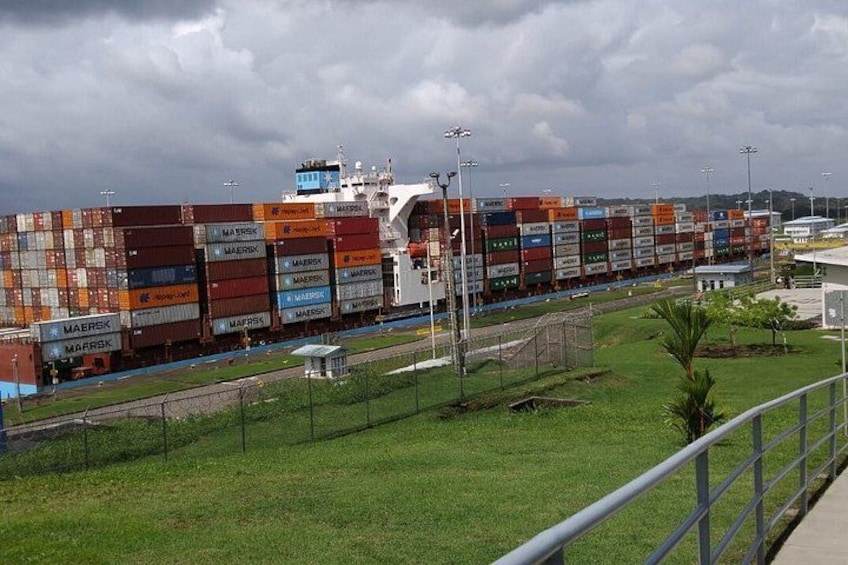 A cargo ship loaded with shipping containers docked at a port. 2