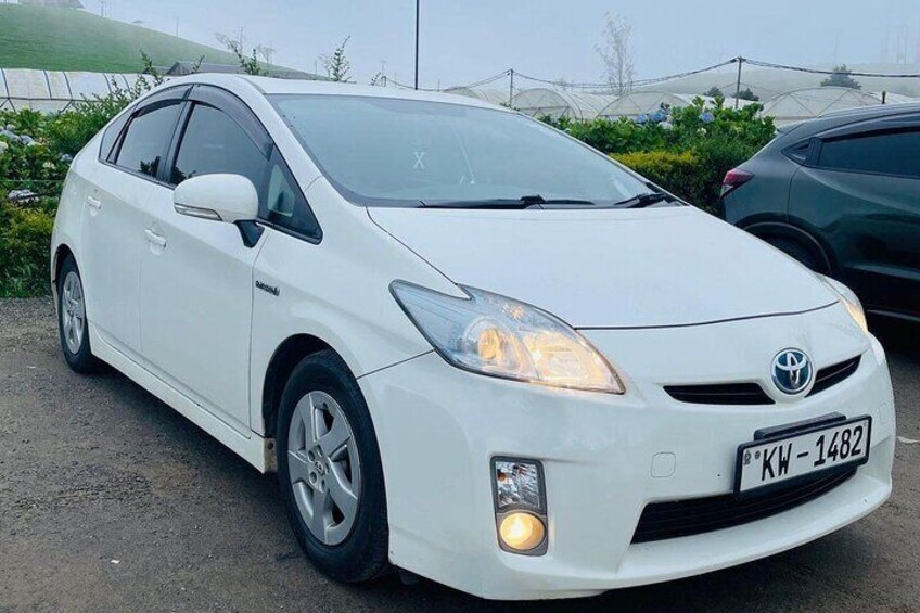 Un Toyota Prius blanco estacionado en un estacionamiento, con la matrícula 'KW-1482'. 3