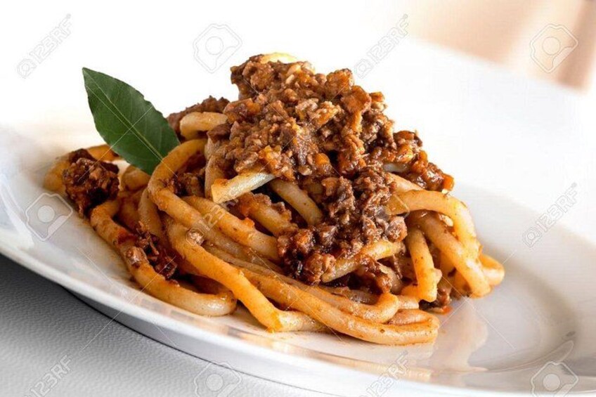Un plato de espagueti con salsa de carne y una hoja de laurel como decoración. 2