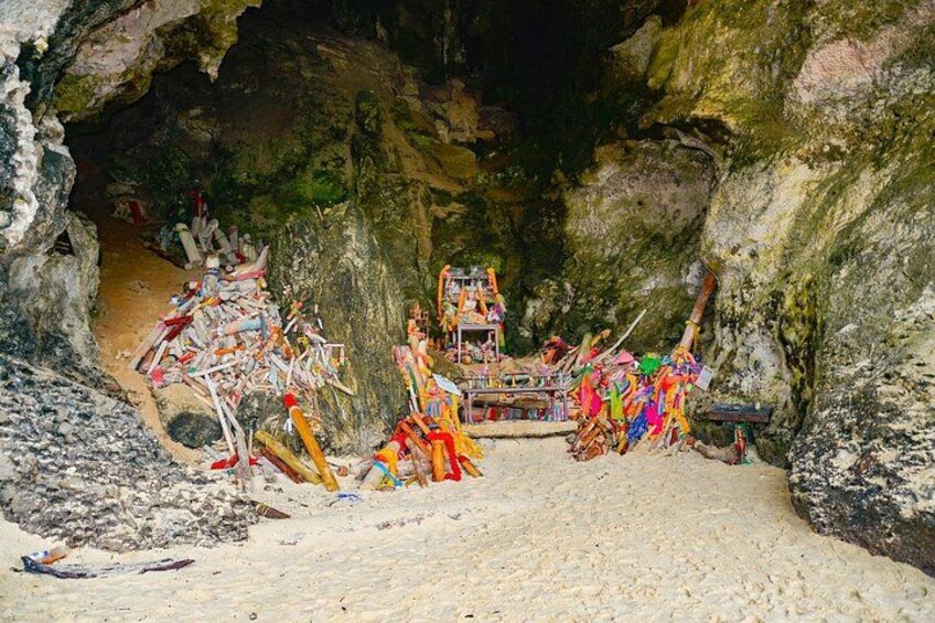 A cave with colorful statues and a shrine. 3
