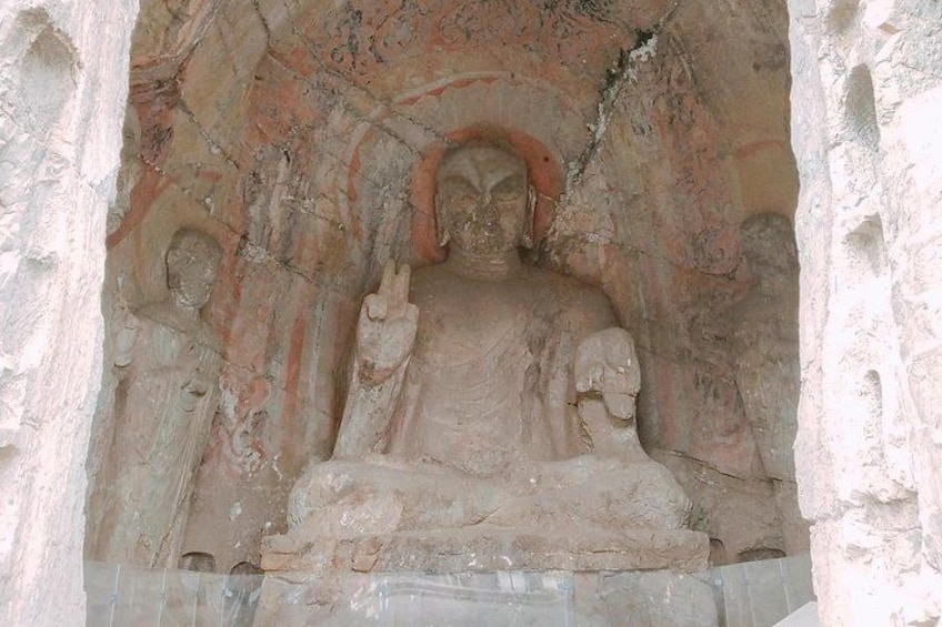 A large stone Buddha statue in a niche with intricate carvings. 2