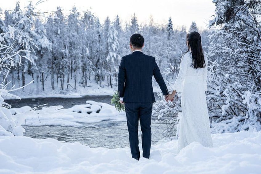 Una coppia cammina in una foresta innevata con un fiume. 4