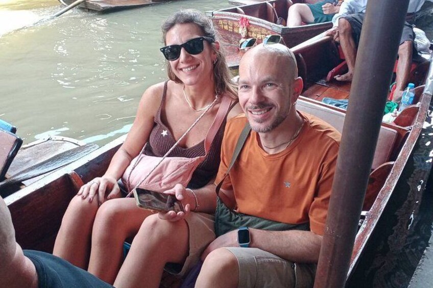 Two people seated in a boat with a water body in the background. 4