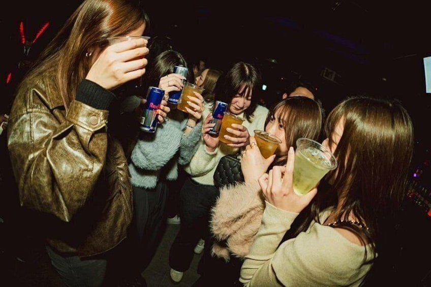 Un grupo de personas sosteniendo bebidas en un evento social. 4