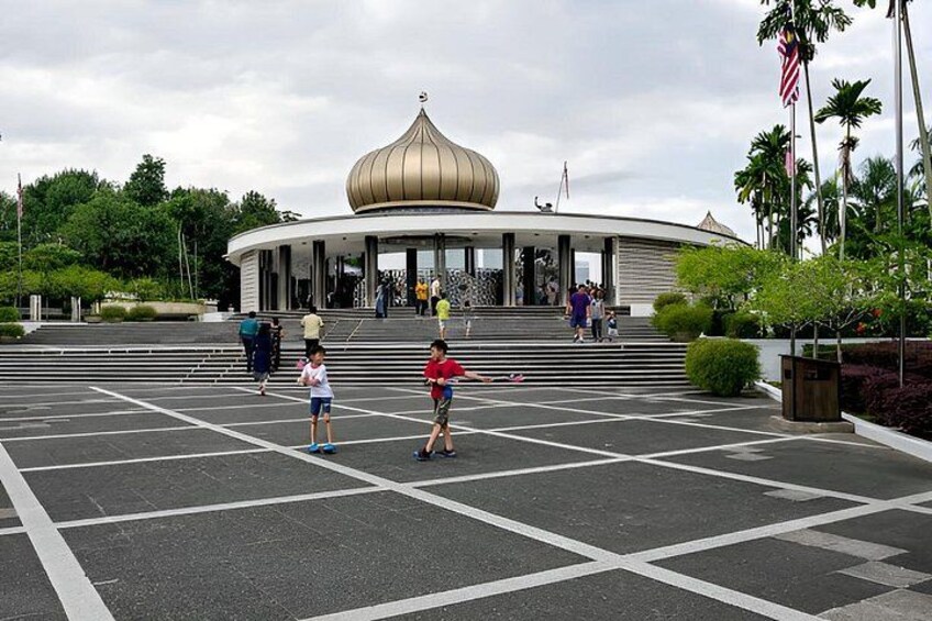Un grande edificio con una cupola, circondato da un parcheggio con posti delimitati. 5