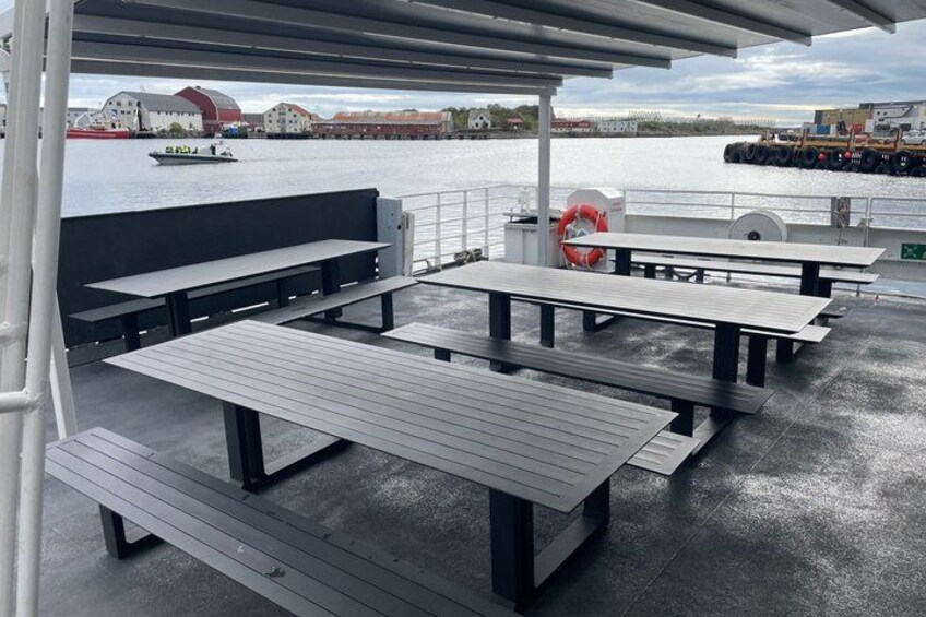 Outdoor seating with a view of the water and buildings in the background. 2