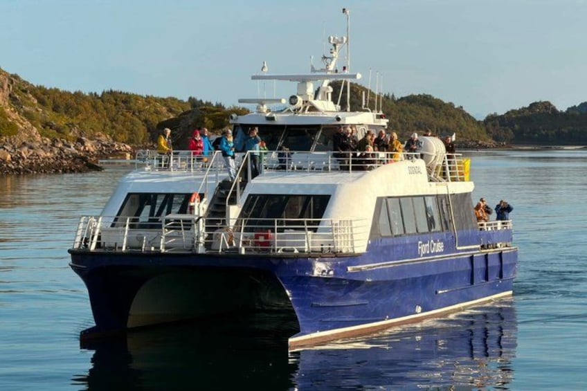 A blue ferry named 'Front Cruiser' with passengers on deck, navigating a calm river. 5