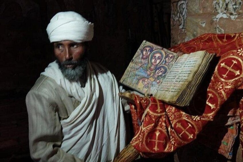 A person holding an open book with ornate designs. 1