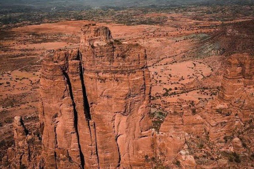 A red rock formation with a prominent vertical crack. 4