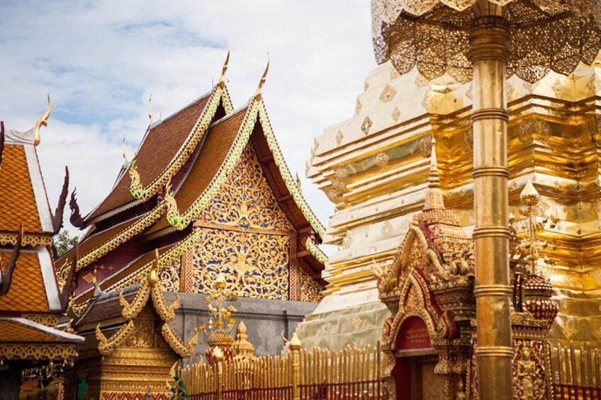 Ornate temple architecture with intricate golden details and a large golden column. 3