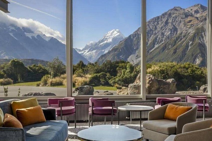 A seating area with a mountain view, including a couch, chairs, and a table. 4