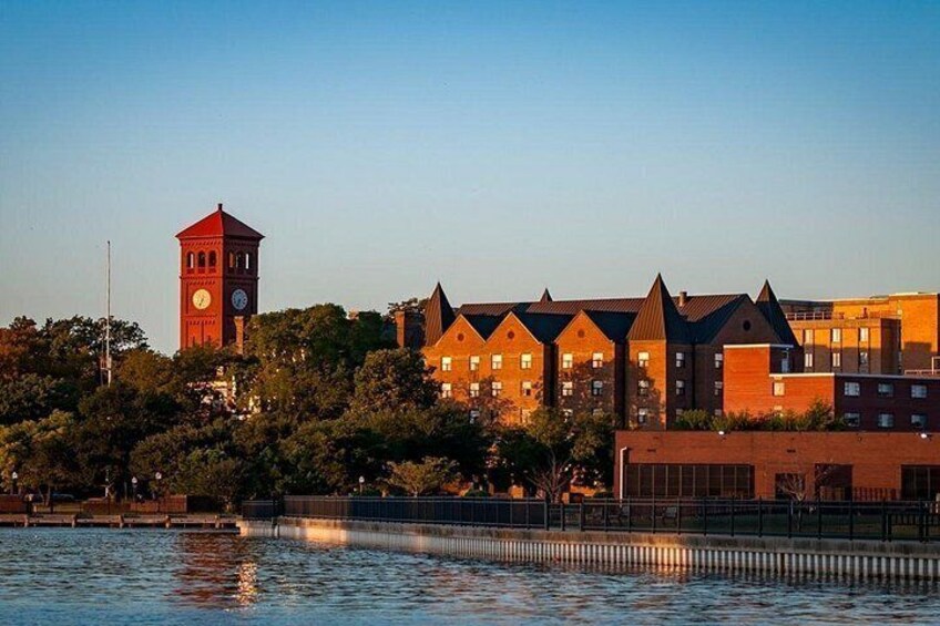 A river with a clock tower and buildings in the background. 2