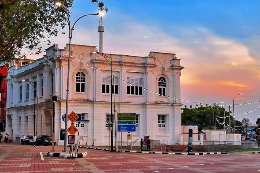 A historic building with classical architecture, a street with a pedestrian crossing, and a clear sky. 3