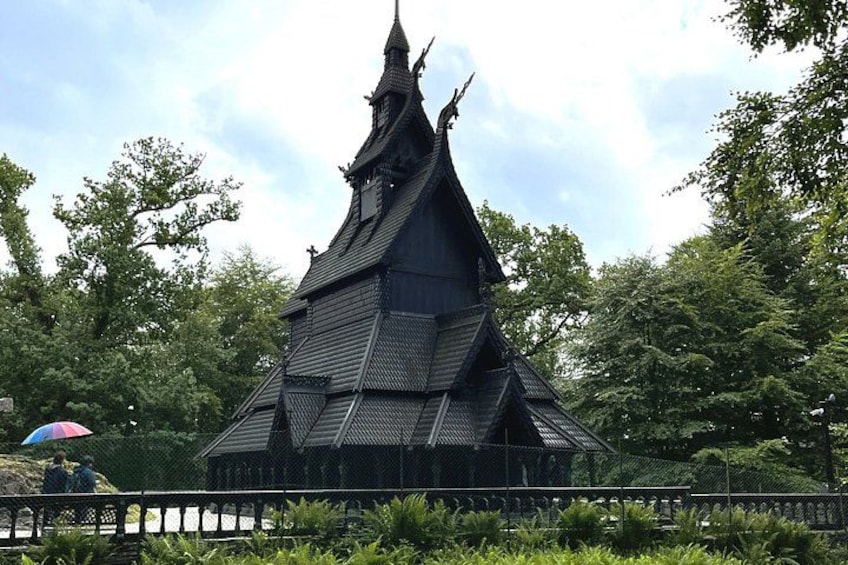 A traditional Thai temple with a pointed roof and intricate design, surrounded by lush greenery. 1