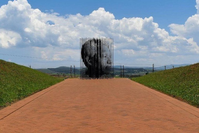 A road leading to a large, abstract sculpture in the distance. 4