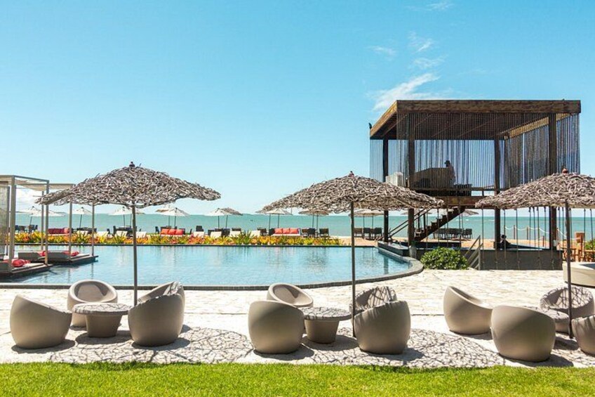 Un espace aménagé au bord de la piscine, avec des chaises longues, des parasols et une piscine. 3