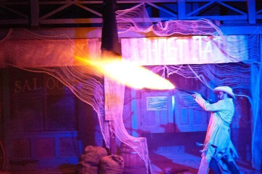 A person performing with a flaming object in a dimly lit indoor setting. 5