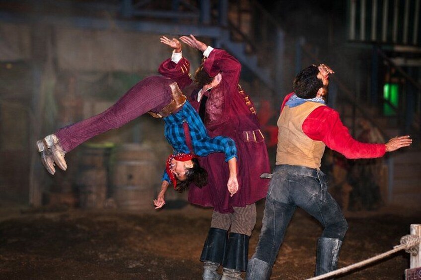 A group of people performing an acrobatic stunt in an industrial setting. 2