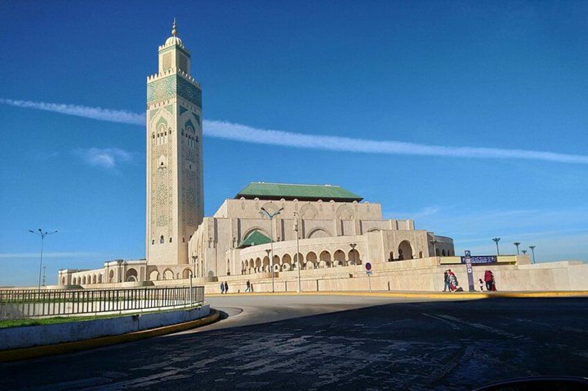En stor moské med ett högt minaret och ett grönt tak. 5