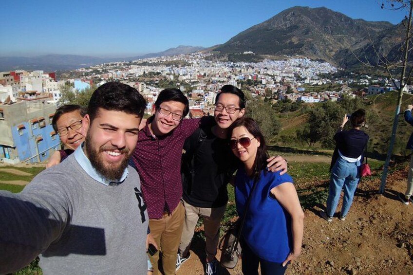 En grupp människor som tar en selfie med en stadsbild och berg i bakgrunden. 4