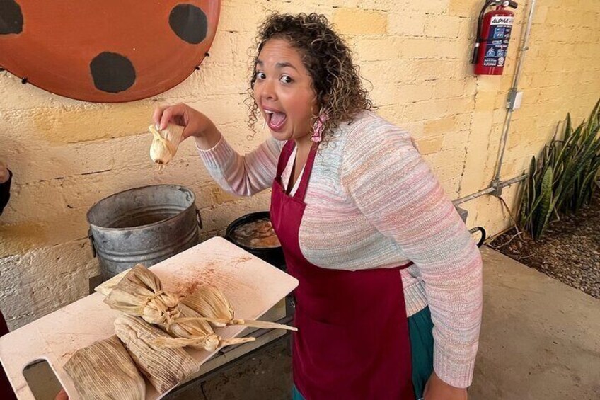 En person laver tamales på en skærebræt. 4