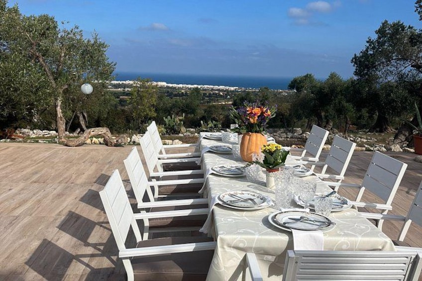 Une table à manger installée à l’extérieur, avec vue sur la mer. 1