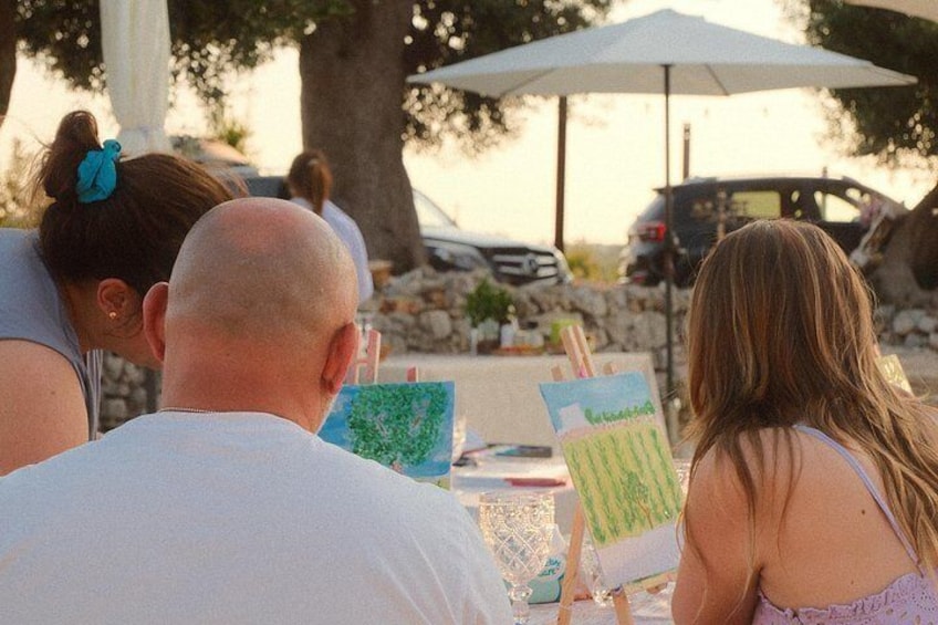 Des personnes sont assises à une table, entourées de matériel de dessin, et semblent être en train de faire une activité de peinture. 5