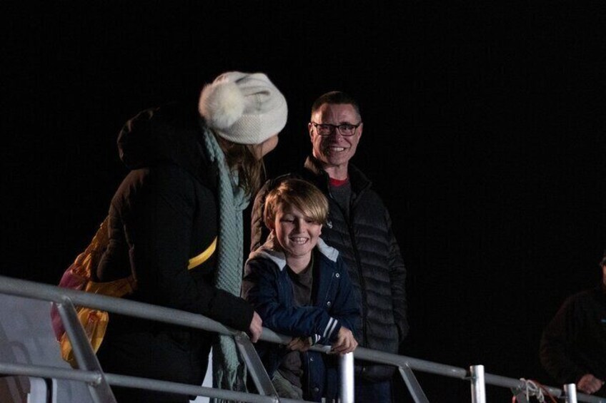 People standing on a bridge at night. 3