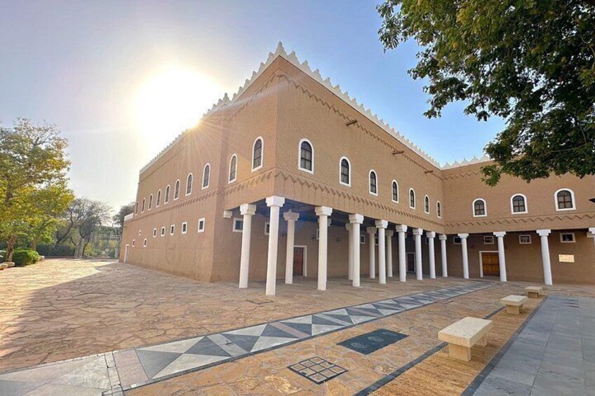 A large building with a tiled courtyard, columns, and a patterned floor. 1