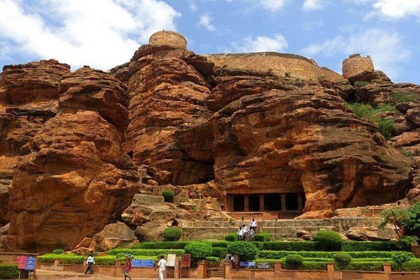 A large rock formation with carved niches and a dome structure. 1
