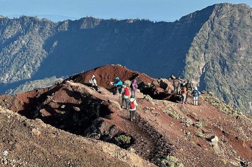 Un grupo de excursionistas en la cresta de una montaña, con un paisaje extenso al fondo. 5