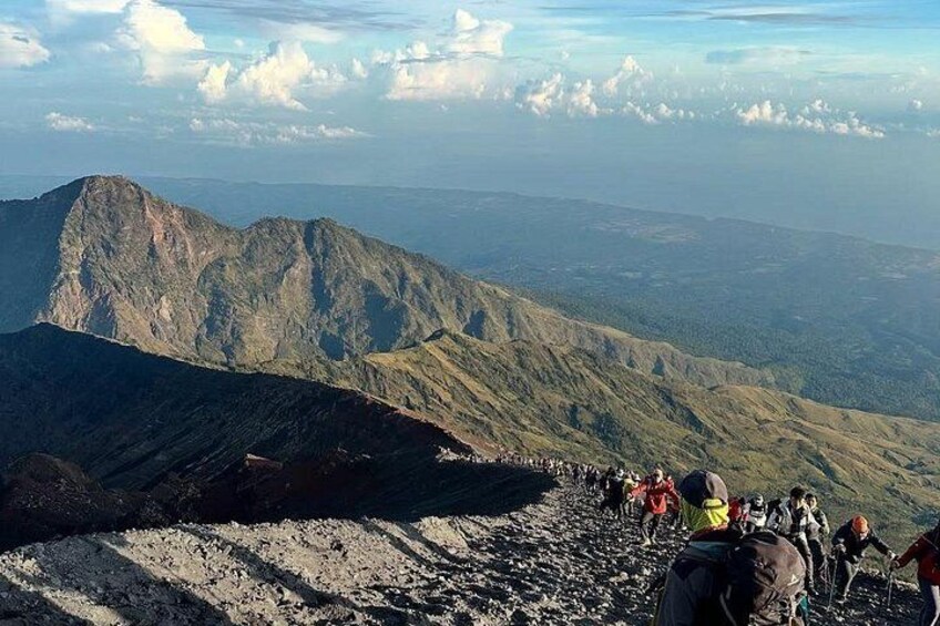 Un paisaje montañoso con excursionistas en un sendero. 4