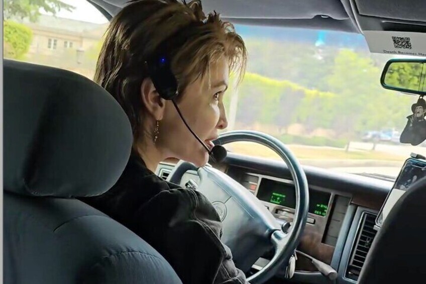 A person driving a car wearing a headset. 1