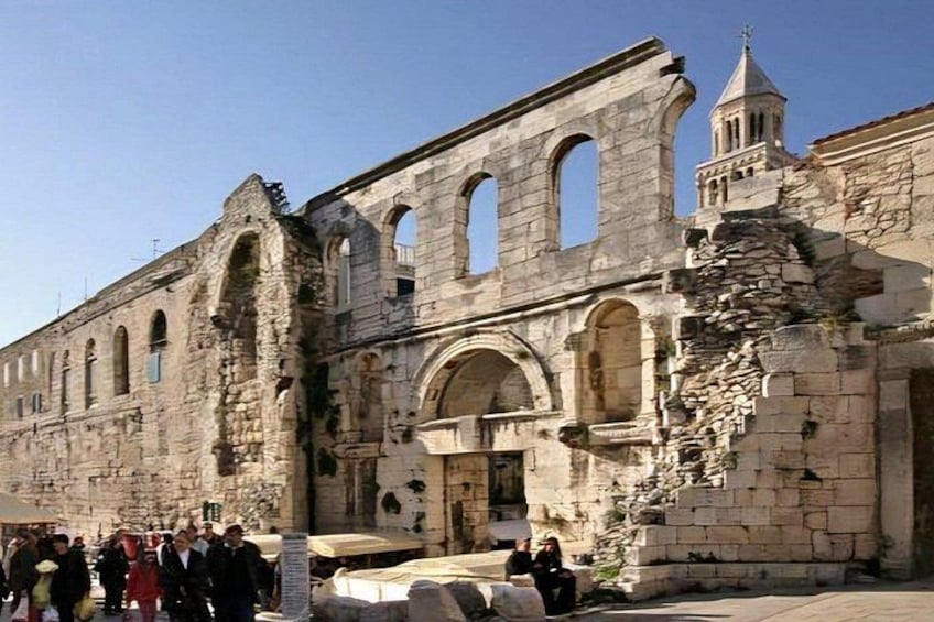 Un edificio histórico de piedra con ventanas de arco y un campanario. 2