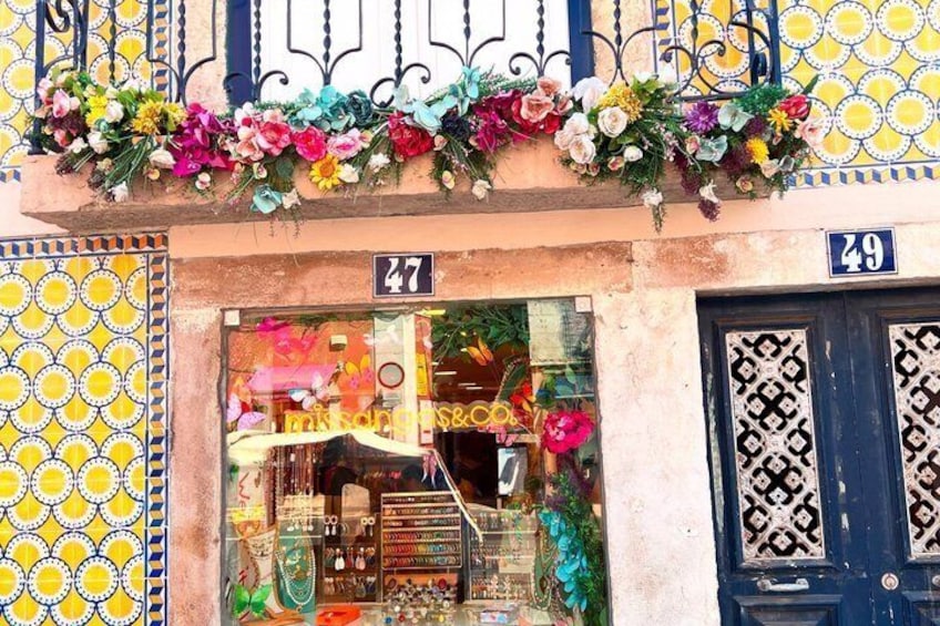 A shop with a colorful display of jewelry and a blue door with a number '49' above it. 2