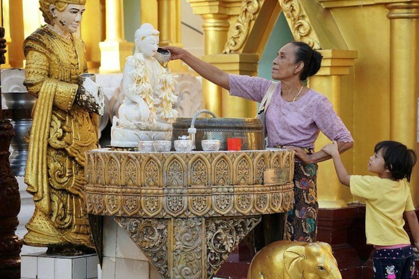 A golden statue, a white statue, and a child interacting with a table. 4