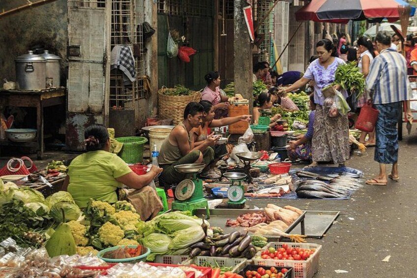 A bustling street market with vendors selling fresh produce and fish. 3