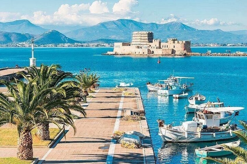 A coastal marina with boats, a lighthouse, and a historic fort. 5
