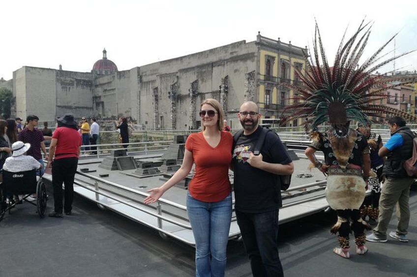 A woman and a man standing on a rooftop with a large decorative plant. 5