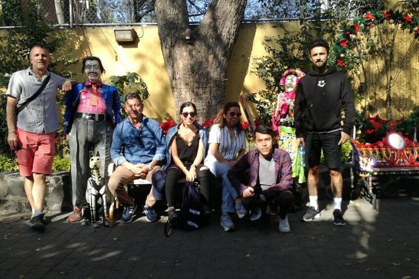 A group of people posing in an outdoor setting with a tree and a decorated table in the background. 3