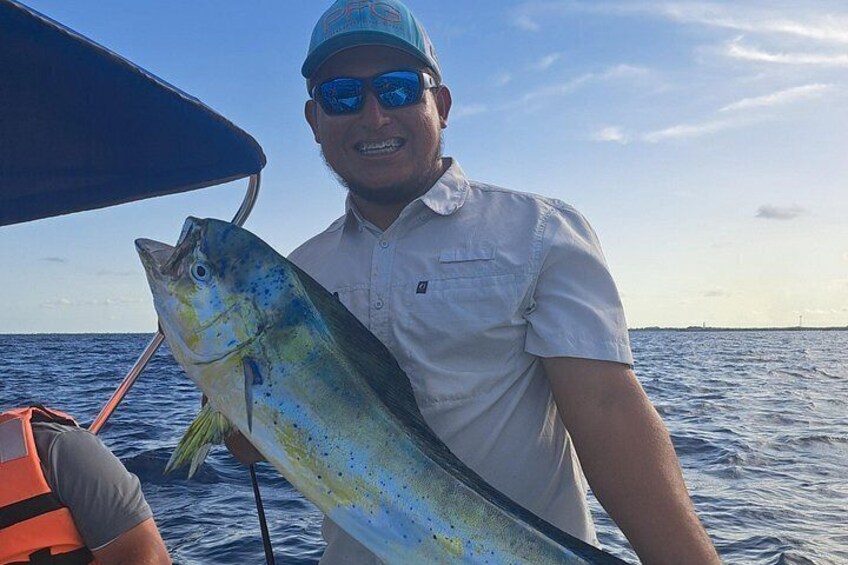 Una persona sostiene un pez grande en un bote en el océano. 1