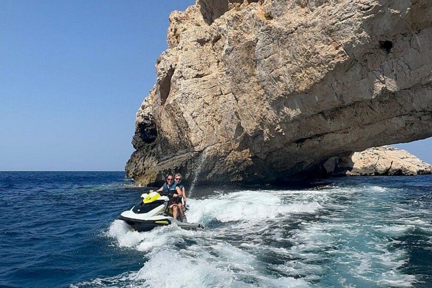 En jetski nær en klippefyldt kystlinje med krystalklart blåt vand. 4