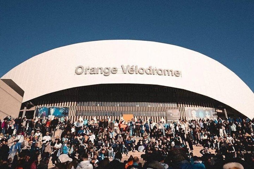 En stor, hvid, buet bygning med teksten 'Orange Vélodrome' på facaden. 1