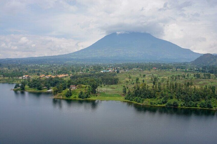 A lake surrounded by greenery and a mountain in the background. 3