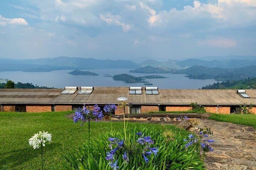 A building with a tiled roof, surrounded by green grass and purple flowers. 4