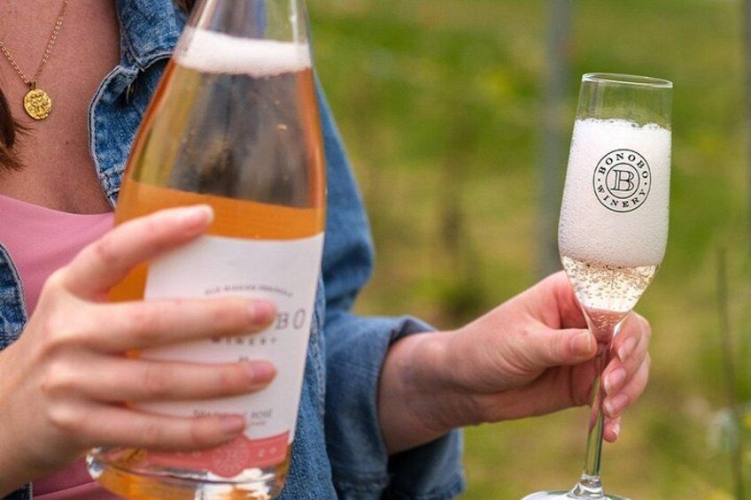 A person holding a bottle and a glass with a logo. 3