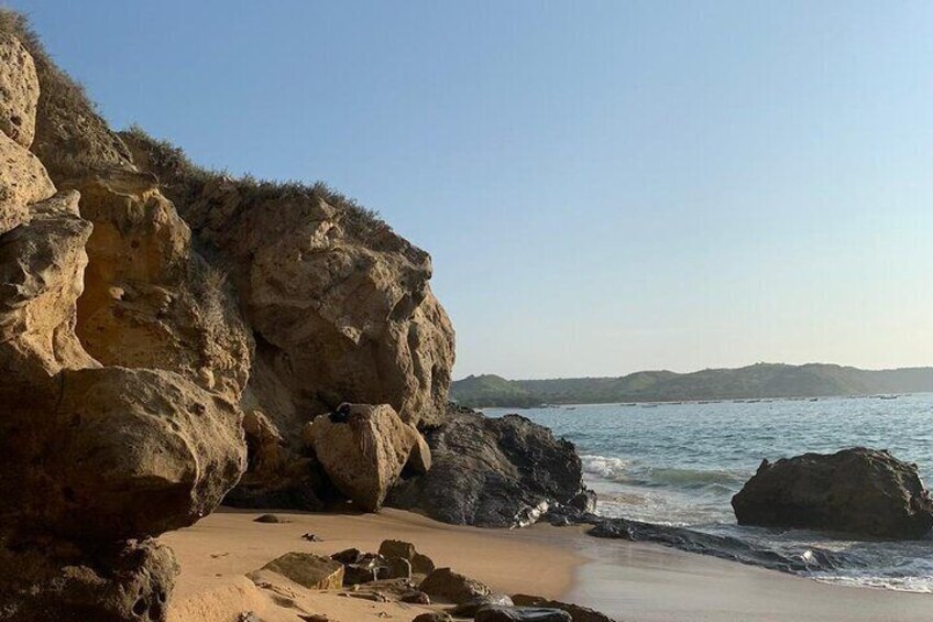 A rocky coastline with waves crashing against the shore and a clear sky. 5