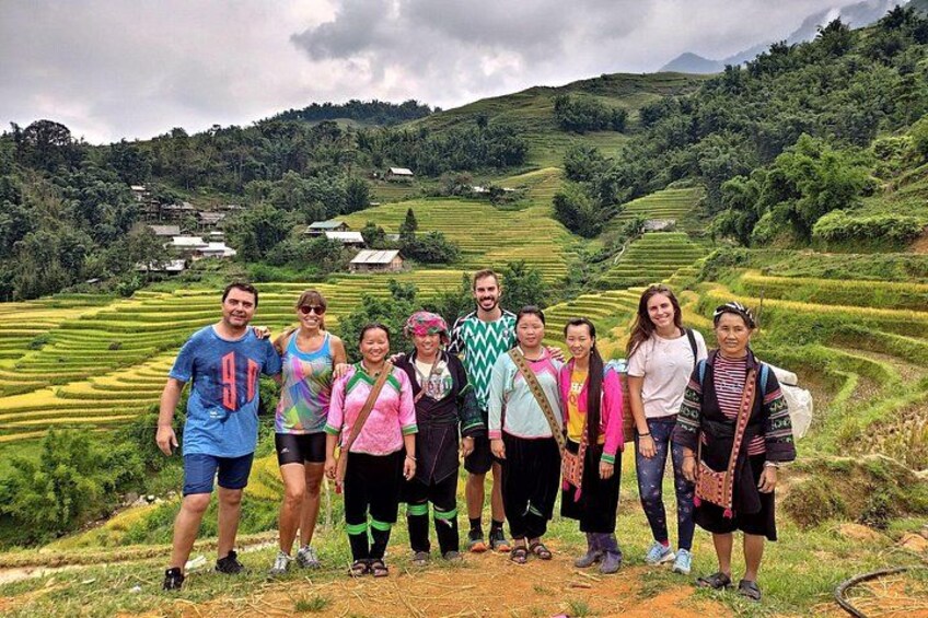 A group of people standing on a hillside with terraced fields in the background. 3
