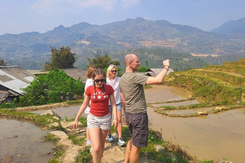 A group of people walking on a terraced hillside with a mountainous landscape in the background. 4